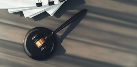 Closeup top view black wooden gavel hammer and legal document on wooden office desk background as...