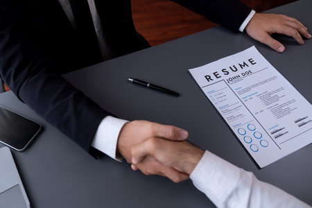 Successful job interview at business office with handshake. Positive discussion of qualifications and application for position. Job hiring concept between candidate and interviewer. Ferventの写真素材