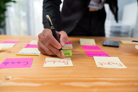 Businessman brainstorming and writing creative idea on colorful post-it notes. Planning and brainstorm strategy to achieve business targets using post notes. ferventの写真素材