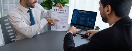 Interviewing job applicant in office with resume paper. Candidate wear suit for formal conversation with interviewer. Recruitment process with question about career and work experience. Ferventの写真素材