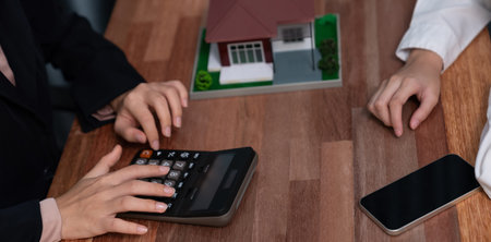 Reviewing house loan contract with agent. Analyzing financial documents and tax rates with...