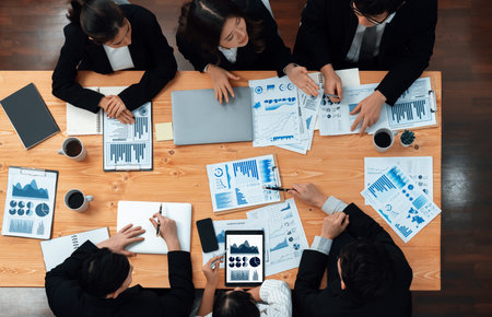 Top-view business team of financial data analysis meeting with business intelligence, report paper and dashboard on laptop for marketing strategy. Business people working together in office of harmonyの写真素材