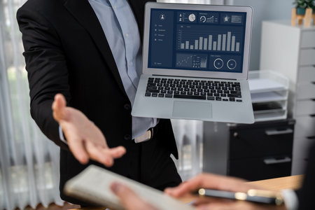 Busy analyst team discussing financial data on digital dashboard, analyzing chart and graph using data science software display on a laptop screen. Business intelligence and Fintech. Ferventの写真素材
