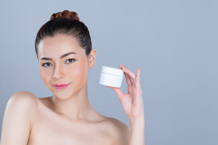 Glamorous beautiful perfect cosmetic skin with soft makeup woman portrait hold mockup jar cream or moisturizer for skincare treatment and anti-aging product advertisement in isolated background.の写真素材