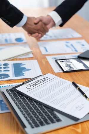 Closeup professional businessman shaking hands over desk in modern office after successfully...