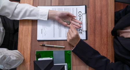 Successful house loan agreement sealed with a top view handshake. Buyers and agents celebrate the home ownership of property with a sense of accomplishment and satisfaction. Enthusiasticの写真素材