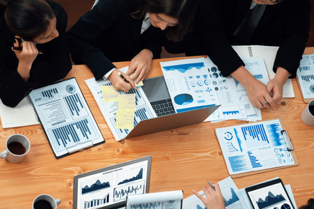 Top-view business team of financial data analysis meeting with business intelligence, report paper and dashboard on laptop for marketing strategy. Business people working together in office of harmonyの写真素材