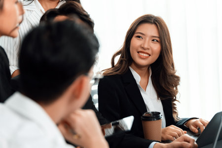 Focus portrait of female manger, businesswoman in the harmony meeting room with blurred of colleagues working together, analyzing financial paper report and dashboard data in background.の写真素材