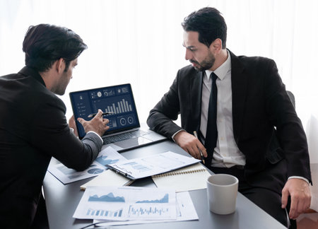 Busy analyst team discussing financial data on digital dashboard, analyzing chart and graph using data science software display on a laptop screen. Business intelligence and Fintech. Ferventの写真素材