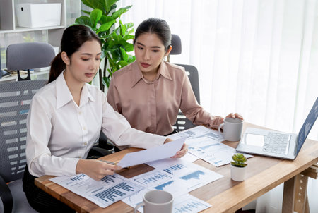 Analyst team colleagues discuss financial data on digital dashboard, analyzing charts and graph with supportive teamwork. Professional office use business intelligence to plan marketing. Enthusiasticの写真素材
