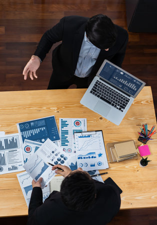 Top view analyst team discussing financial data on digital dashboard, analyzing chart and graph papers by data science software on wooden table background. Business intelligence and Fintech. Ferventの写真素材