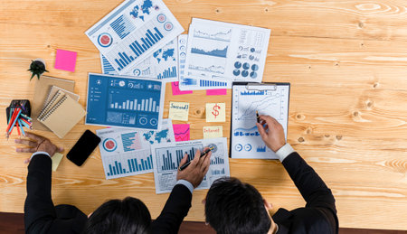Top view analyst team discussing financial data on digital dashboard, analyzing chart and graph...