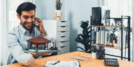 Happy buyer successfully buy a house with a house loan after signing contract, holding key and talking on phone with joy. Excited celebration after real estate success. Ferventの写真素材