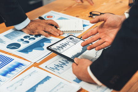 Closeup busy analyst team discussing financial data on digital dashboard, analyzing chart and graph using data science software display on a laptop screen. Business intelligence and Fintech. Ferventの写真素材