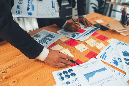 Busy analyst team discuss financial data on digital dashboard, plan goal and brainstorm idea with sticky note. Utilizing business intelligence and Fintech technology concept. Ferventの写真素材