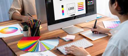 Graphic designer work on computer laptop and with graphic drawing pen while brainstorming unique...