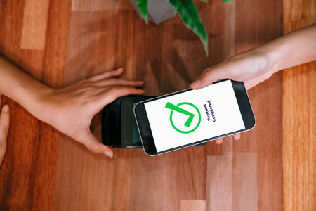 QR code is displayed on screen for cashless payment scanning. Closeup hands hold smartphone to transfer money by electronic transaction from mobile app. Bar code technology for fast pay. Enthusiasticの写真素材