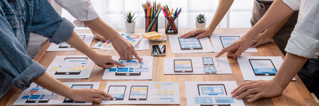 Panorama shot of front-end developer team brainstorming UI and UX designs for mobile app on paper...