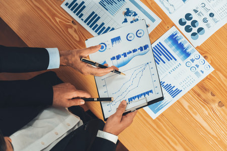 Top view analyst team discussing financial data on digital dashboard, analyzing chart and graph papers by data science software on wooden table background. Business intelligence and Fintech. Ferventの写真素材