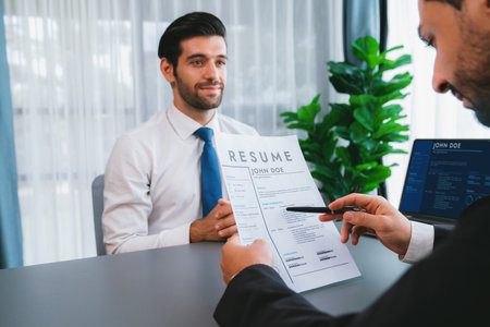 Interviewing job applicant in office with resume paper. Candidate wear suit for formal conversation with interviewer. Recruitment process with question about career and work experience. Ferventの写真素材