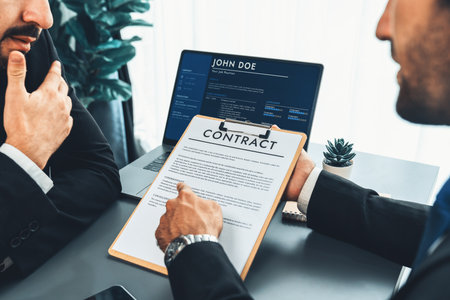 Closeup business deal meeting, businessman carefully reviewing terms and condition of contract agreement papers in office. Corporate lawyer give consultation on contract deal. Ferventの写真素材