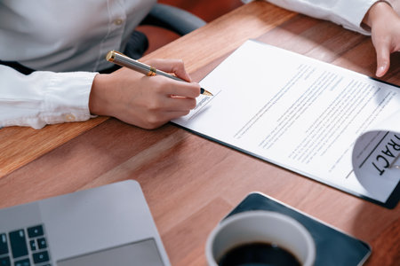 Closeup hand signing contract document with pen, sealing business deal with signature. Businesspeople finalizing business agreement by writing down signature on contract paper. Enthusiasticの写真素材