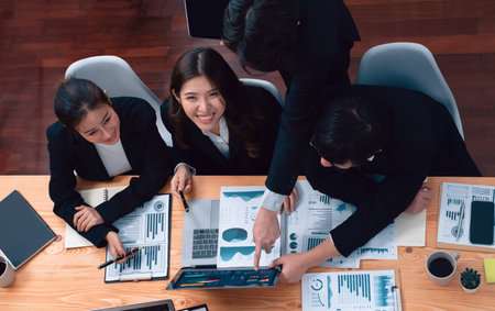 Top-view business team of financial data analysis meeting with business intelligence, report paper and dashboard on laptop for marketing strategy. Business people working together in office of harmonyの写真素材