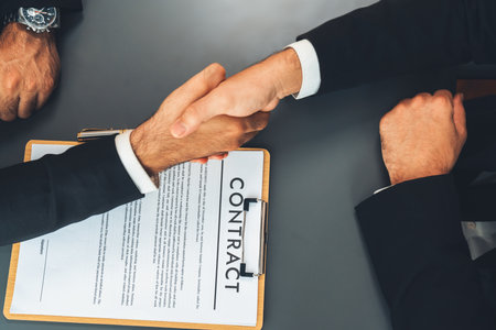 Two professionals successfully close business deal with top view handshake, sealing the partnership agreement. Legal document and handshaking as formal agreement between two companies. Ferventの写真素材
