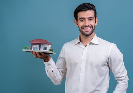 Real estate agent hold house model sample on isolated background. Housing business showcase with copy space. Realtor presenting property investment opportunity on house loan idea. Ferventの写真素材