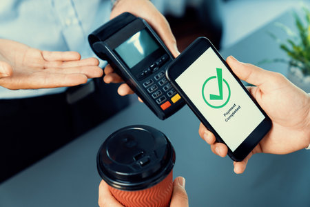 Hand holding smartphone with NFC QR code device, scanning contactless payment code for fast digital...