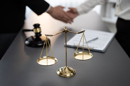 Focus gavel and justice scale on blur background of lawyer colleagues handshake after successful legal deal for lawsuit to advocate resolves dispute in court ensuring trustworthy partner. Equilibriumの写真素材