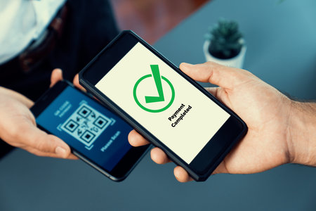 QR code displayed on screen for cashless payment scanning. Closeup hands hold smartphone to transfer...