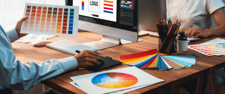 Graphic designer work on computer laptop and with graphic drawing pen while brainstorming unique design with professional graphic team in modern digital studio workplace. Panorama shot. Scrutinizeの写真素材