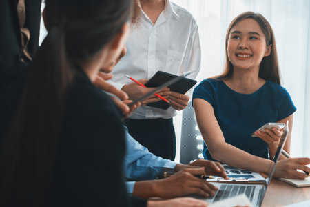 Happy diverse business people work together, discussing in corporate office. Professional and diversity teamwork discuss business plan on desk with laptop. Modern multicultural office worker. Concordの写真素材