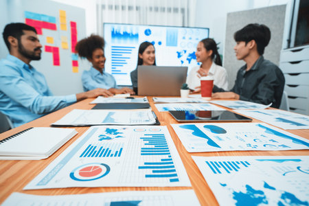 Focus financial dashboard paper showing graphs and chart with blurred background of diverse business...