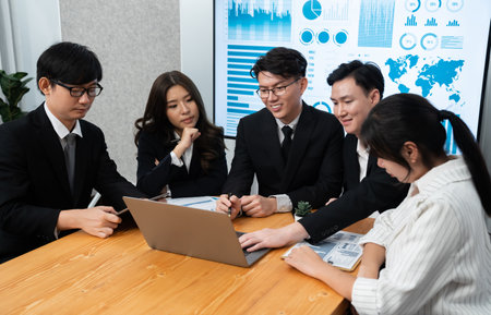 Business team of financial data analysis meeting with business intelligence, report paper and dashboard on laptop for marketing strategy. Business people working together to promote harmony in office.の写真素材