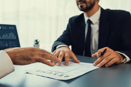 Interviewing job applicant in office with resume paper. Candidate wear suit for formal conversation with interviewer. Recruitment process with question about career and work experience. Ferventの写真素材