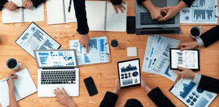 Top-view business team of financial data analysis meeting with business intelligence, report paper and dashboard on laptop for marketing strategy. Business people working together in office of harmonyの写真素材