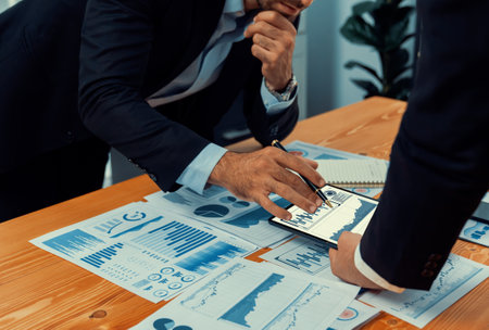 Closeup busy analyst team discussing financial data on digital dashboard, analyzing chart and graph using data science software display on a laptop screen. Business intelligence and Fintech. Ferventの写真素材