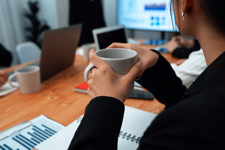 Businesswoman take coffee break, leisure in office after planning strategy, working in office for concept of harmony in workspace concept. Business office worker sitting professional meeting table.の写真素材