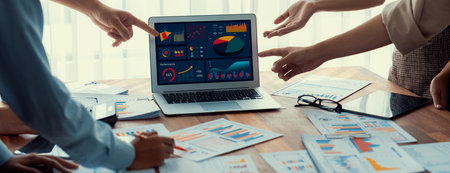 Panorama shot analyst team utilizing BI Fintech to analyze financial report with laptop. Businesspeople analyzing BI power dashboard displayed on laptop screen for business insight. Scrutinizeの写真素材