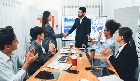 Diverse coworker celebrate with handshake and teamwork in corporate workplace. Happy business people...