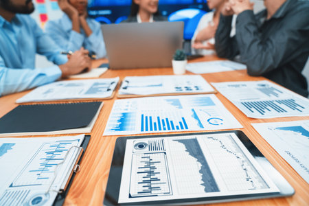 Focus financial dashboard paper showing graphs and chart with blurred background of diverse business people analyzing business data by BI Fintech technology for business marketing indication. Concordの写真素材