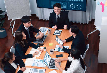 Top-view business team of financial data analysis meeting with business intelligence, report paper and dashboard on laptop for marketing strategy. Business people working together in office of harmonyの写真素材