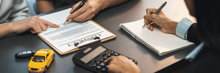 Car dealer calculate interest rate and costs of car loan with calculator, explaining details to...