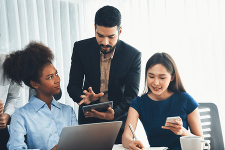 Happy diverse business people work together, discussing in corporate office. Professional and diversity teamwork discuss business plan on desk with laptop. Modern multicultural office worker. Concordの写真素材