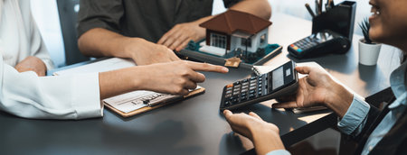 Panorama view of real estate broker calculate tax and interest with calculator, discuss term and agreement with client for house loan and property purchase. Financial agent for home buyer. Prodigyの写真素材