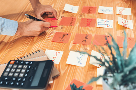 Business team gather on table, brainstorming and writing creative idea on colorful notes. Planning...