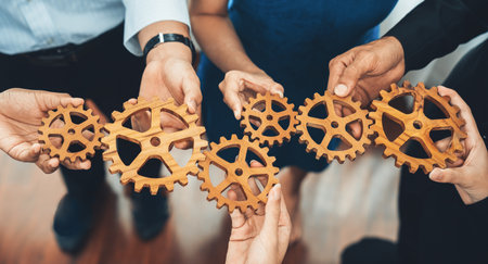 Office worker holding cog wheel as unity and teamwork in corporate workplace concept. Diverse colleague business people showing symbol of visionary system and mechanism for business success. Concordの写真素材