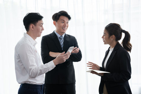 Mentor, manager advice younger colleagues in workplace. Businesspeople discussing or planning financial project strategy, talking together for harmony and strong teamwork in office concept.の写真素材